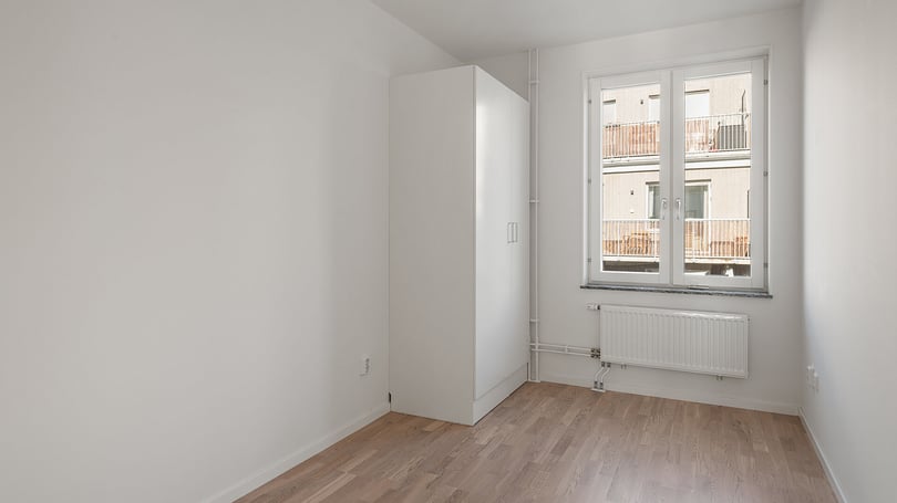 Inflyttningsklar lägenhet med ljusrum, vit garderob och fönster mot innergård