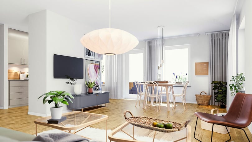 Rum i ljus öppen planlösning med vardagsrum och matplats, vita väggar och trägolv