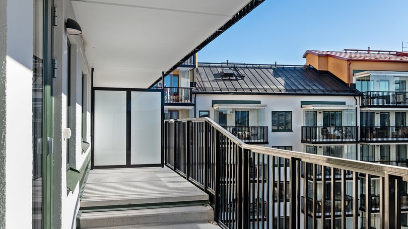 Inflyttningsklar lägenhet med balkong och utsikt mot moderna flerbostadshus