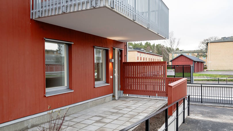 Röd fasad, balkong och uteplats