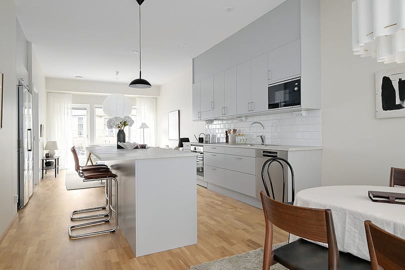 Lägenhet med öppen planlösning med kök, matplats och ljusa trägolv