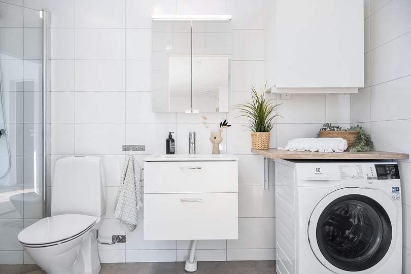Inflyttningsklart badrum med toalett, dusch, handfat och tvättmaskin