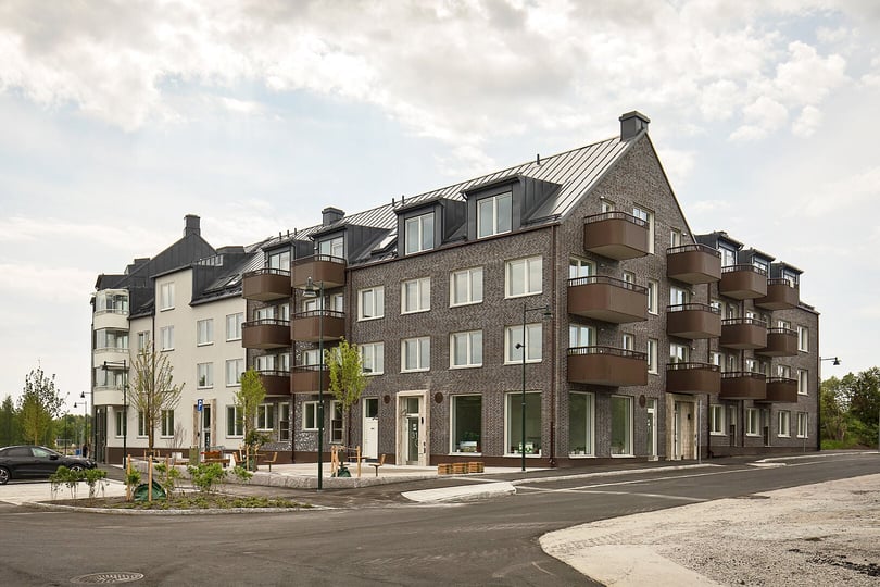 Flerbostadshus med balkonger och nyanlagd gård