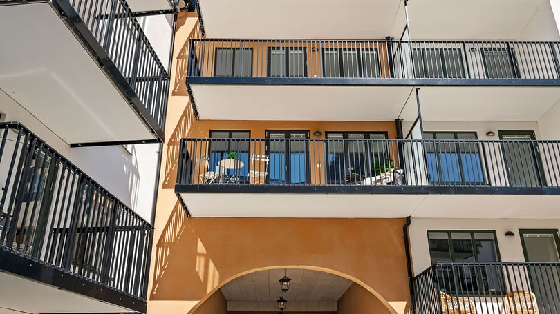Flerbostadshus med moderna balkonger och fasad i varma färger