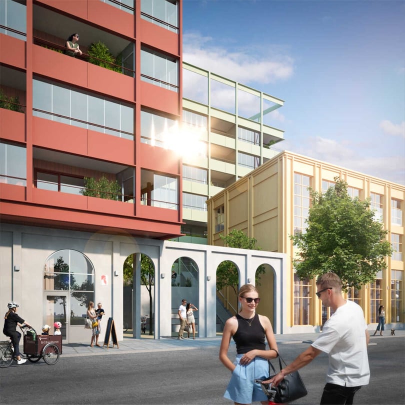 Ett modernt stadskvarter med flerfamiljshus, stora fönster och balkonger, omgivna av träd och människor på en solig dag