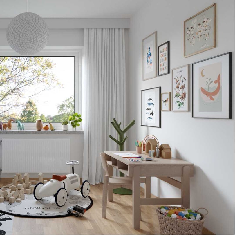 Ljust barnrum med skrivbord, leksaker och fönster mot trädgård