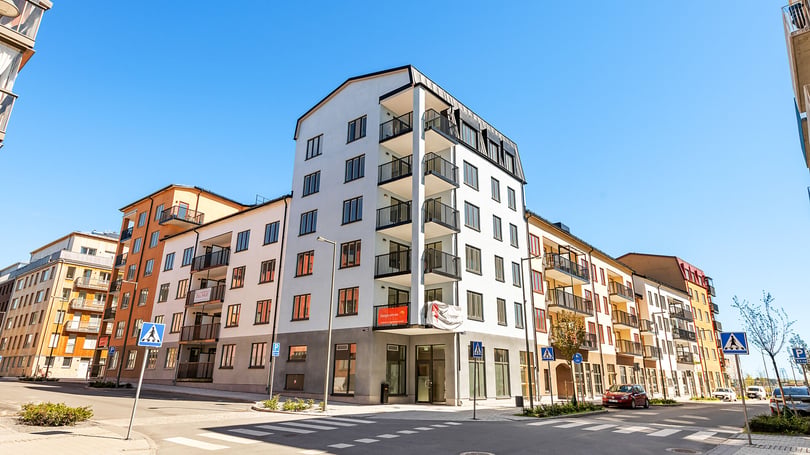 Modernt flerbostadshus i Norrtälje med balkonger och klarblå himmel