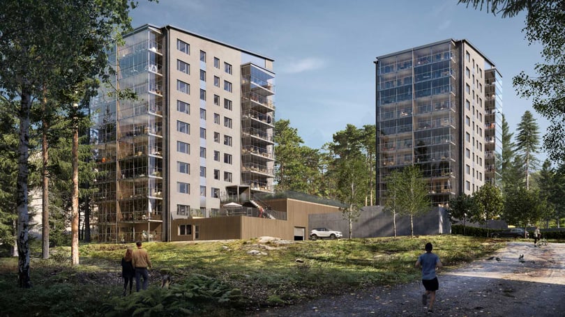 Två moderna flerfamiljshus i ett grönskande område med människor som promenerar i förgrunden