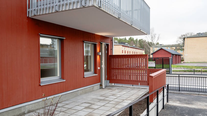 Röd fasad, balkong och uteplats