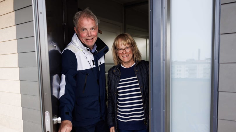 Två personer står i en dörröppning till en lägenhet.