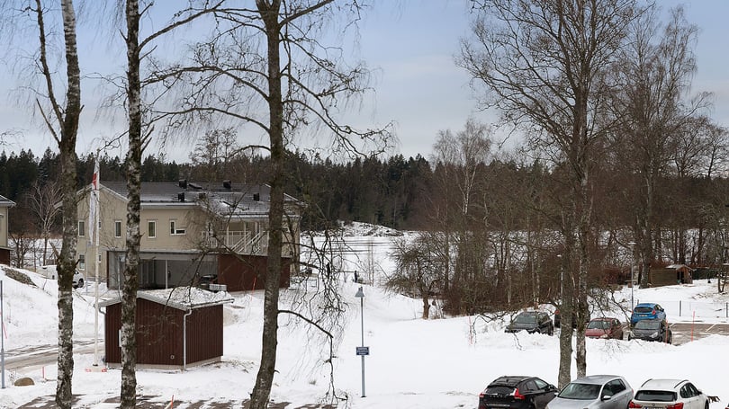 Vintermiljö med hus, träd och parkerade bilar
