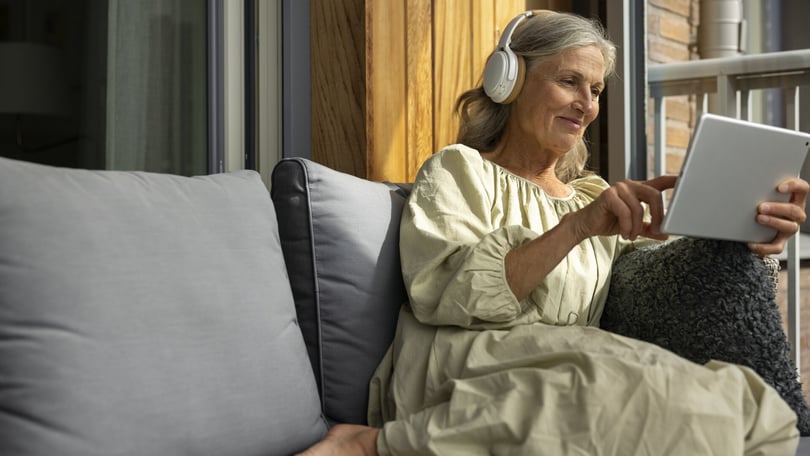 Senior med iPad på balkong