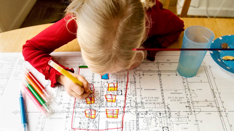 Flicka ritar på en ritning över hus