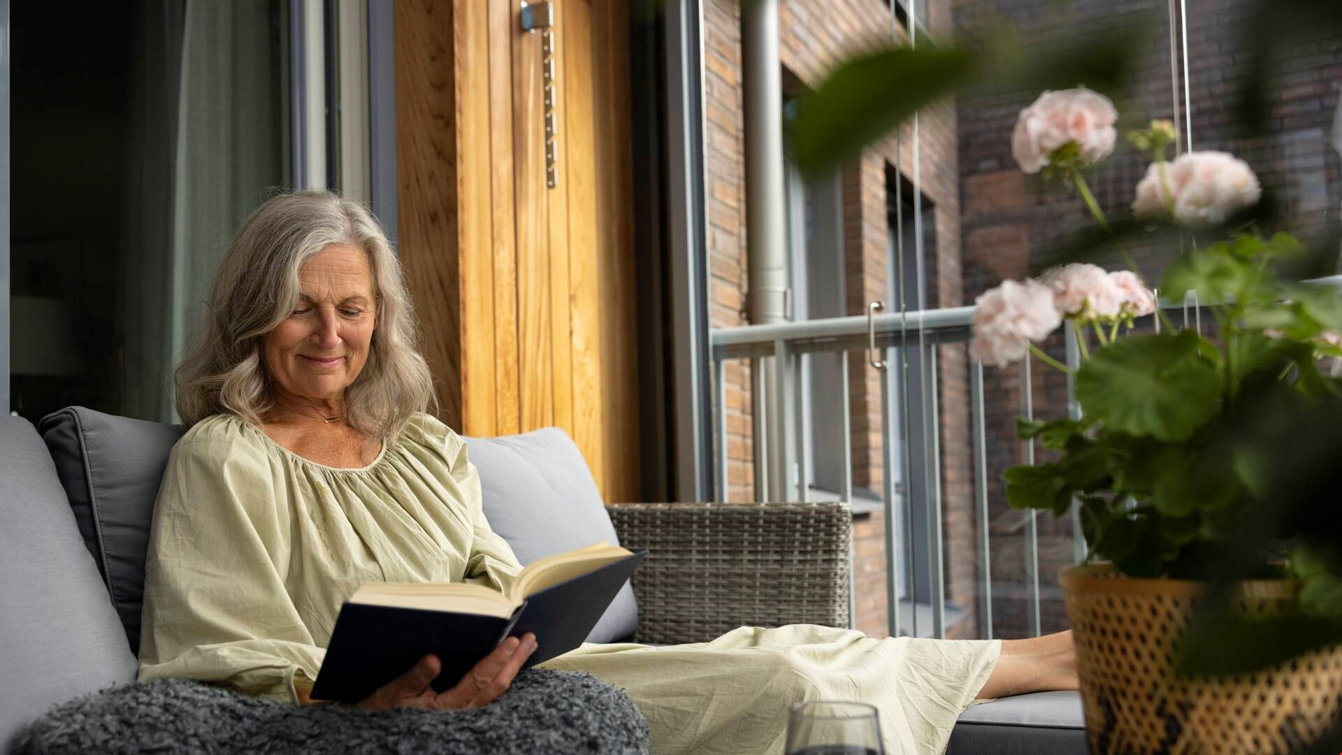 Kvinna läser bok på balkong generell bild