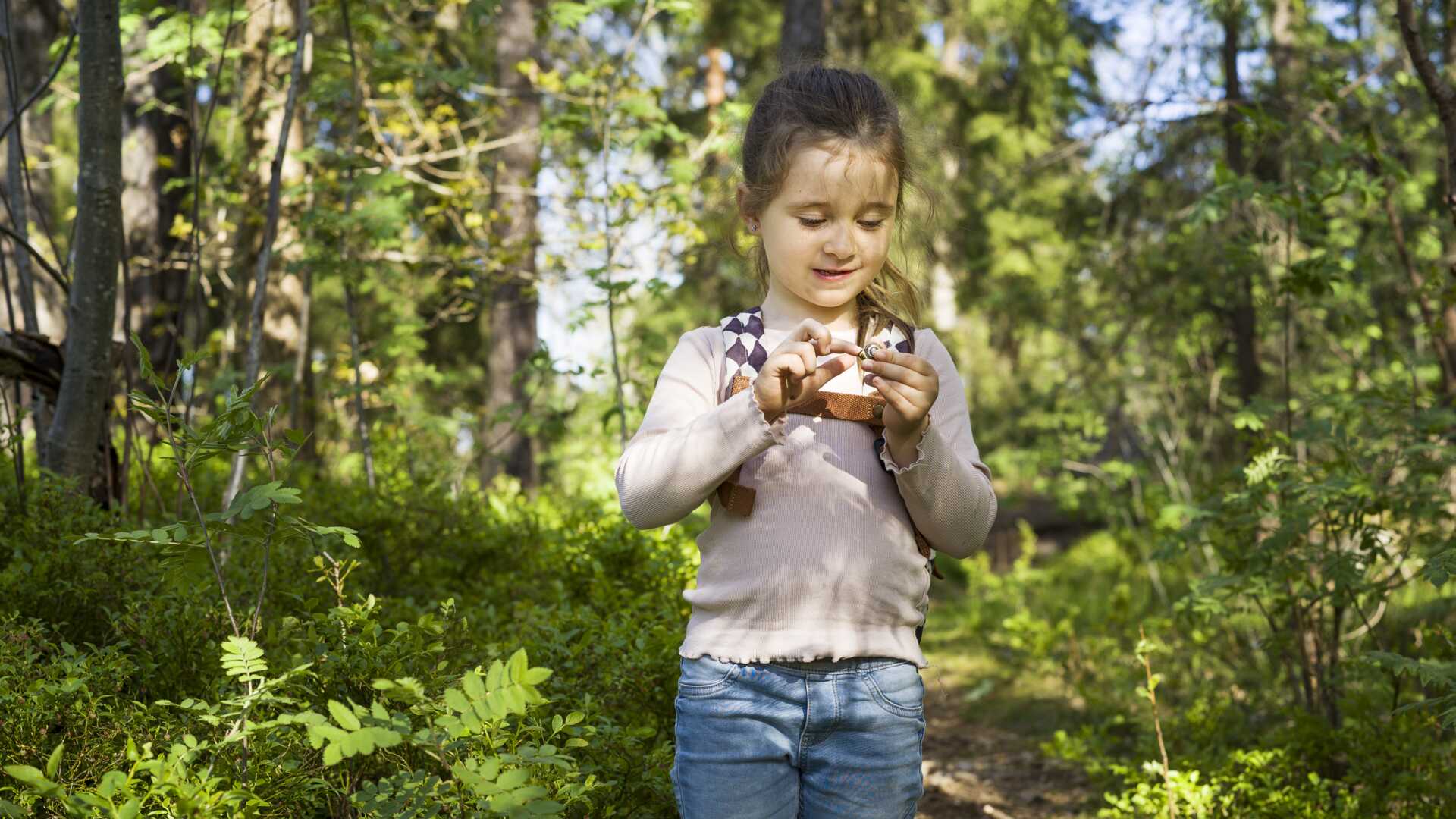 Flicka med snigel i skogen