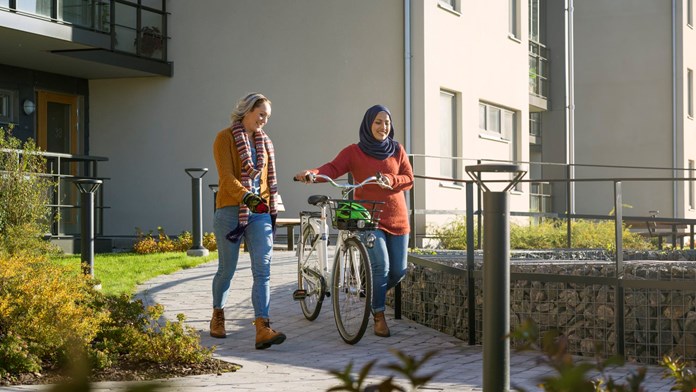 Två kvinnor med en cykel på innergård