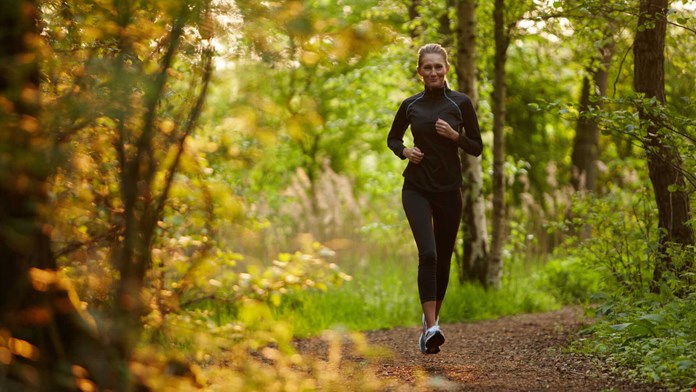 Kvinna joggar i skogen