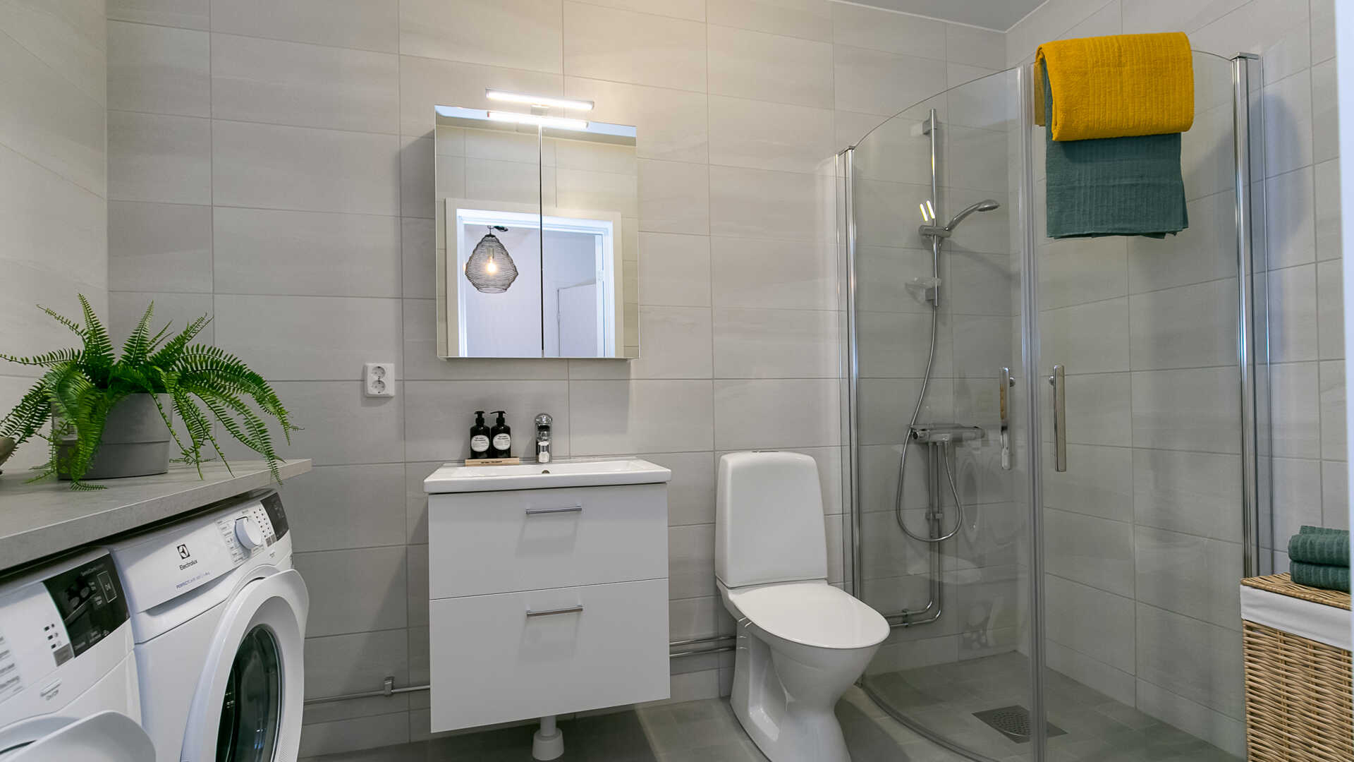 Badrum med duschhörna och tvättmaskin och torktumlare