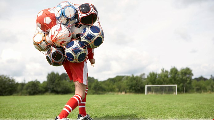 Pojke med nät fyllt med fotbollar