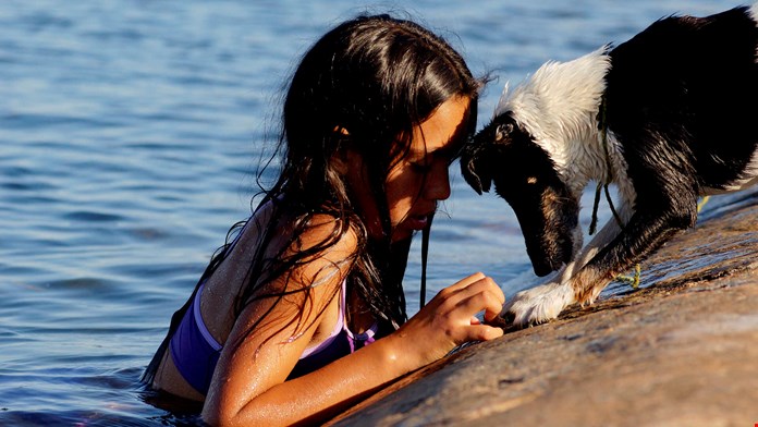 Flicka badar med hund