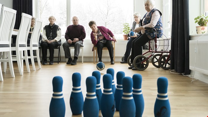 Seniorer spelar bowling på omsorgsboende